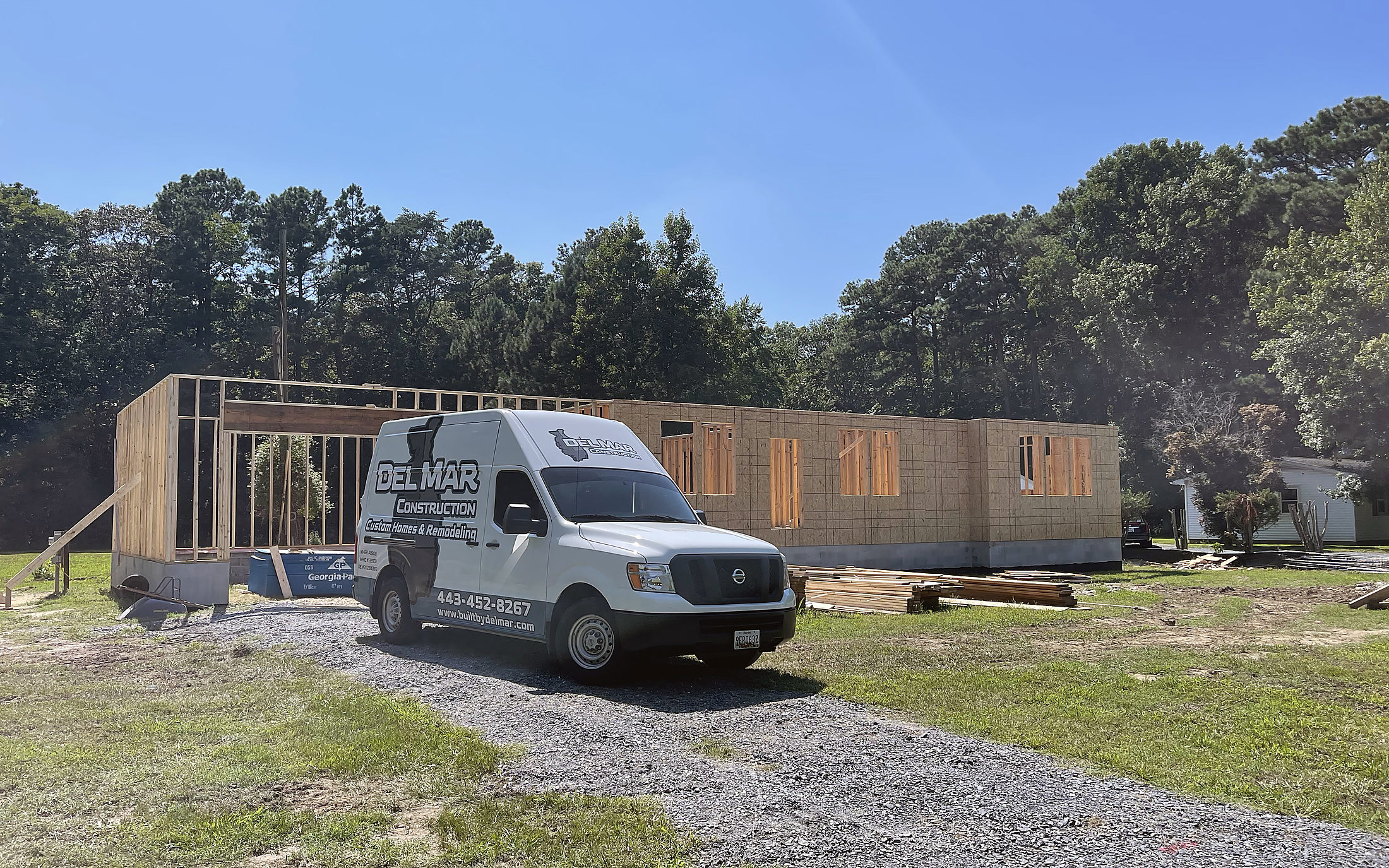 A home addition framed out with the Del Mar Construction van on site