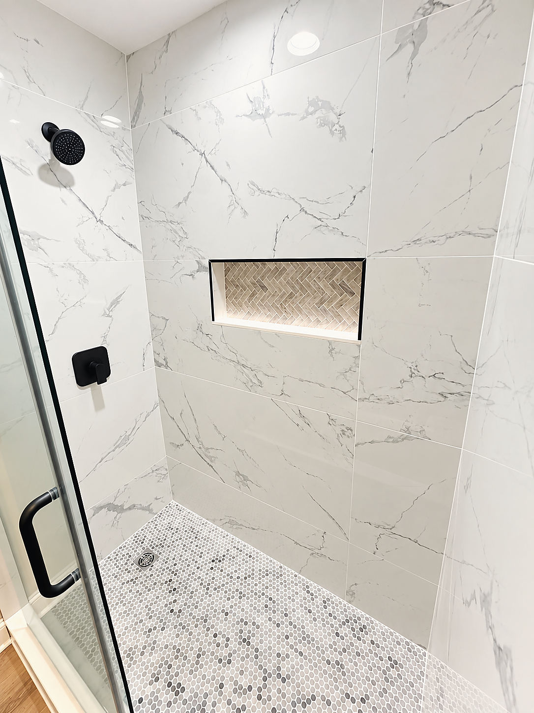 A Del Mar bathroom: a marble-look shower with a niche