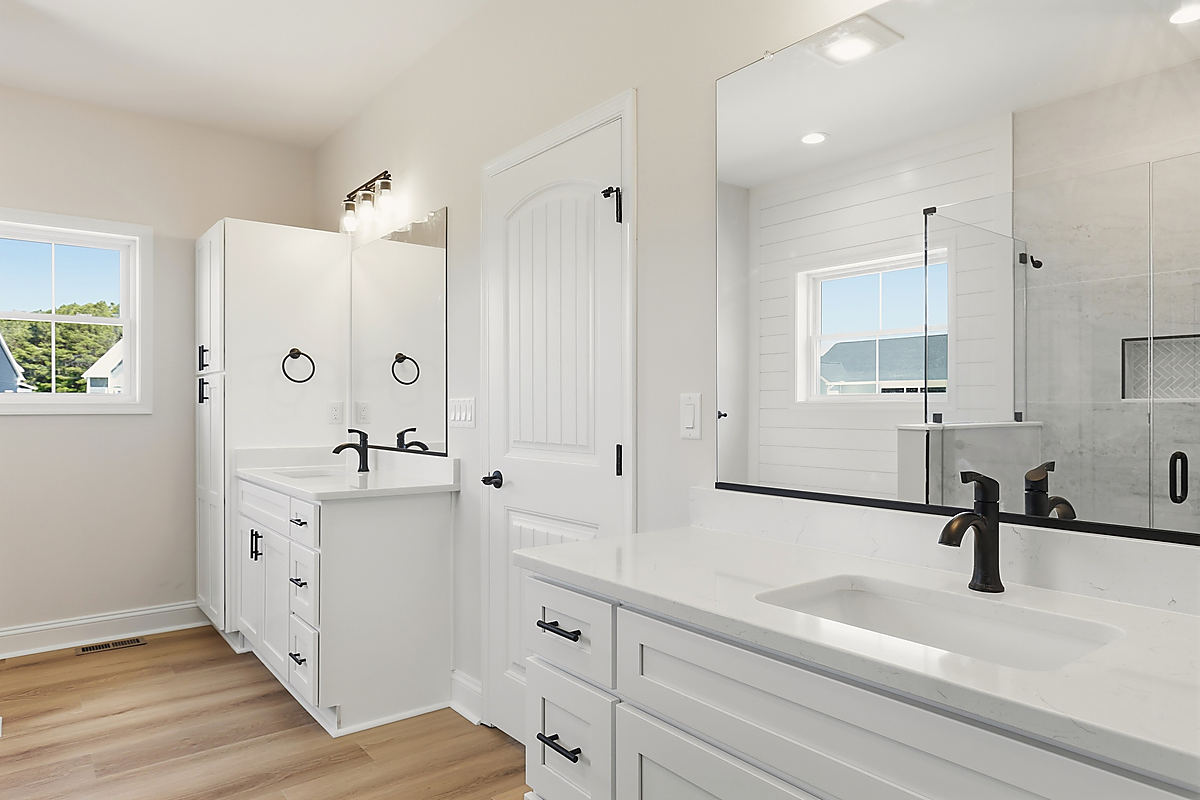 A Del Mar bathroom: a white double vanity with black fixtures