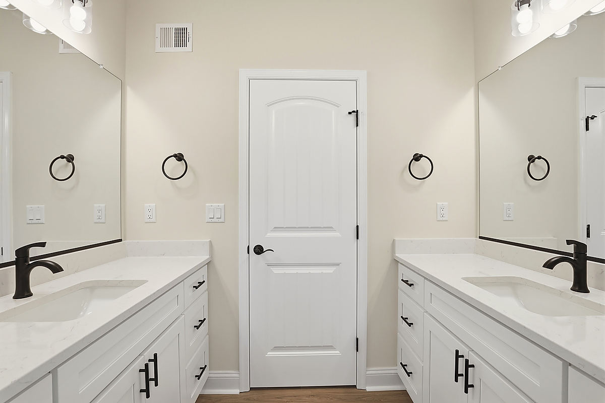A Del Mar bathroom: a marble-look shower behind black-framed glass