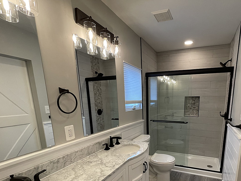 A bathroom remodel with a double vanity and marble counters