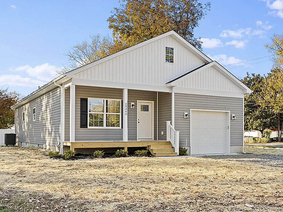 A gray cottage with new gutters and a covered porch