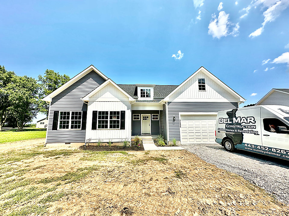 A gray and white custom home with the Del Mar van