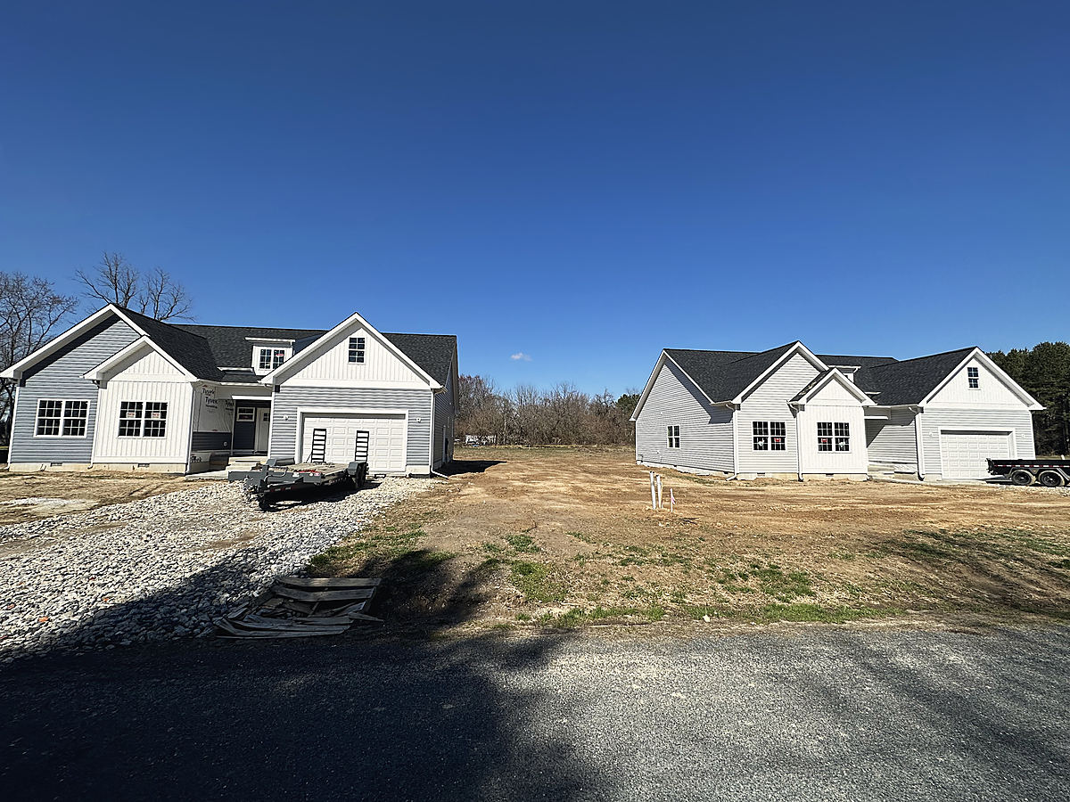 Four custom homes in Cordova: the garage side of a new home under a blue sky