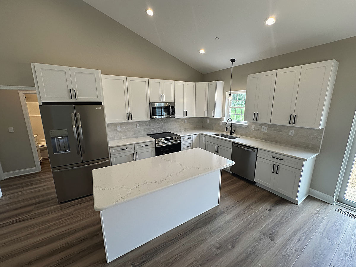 Four custom homes in Cordova: a white kitchen with an island
