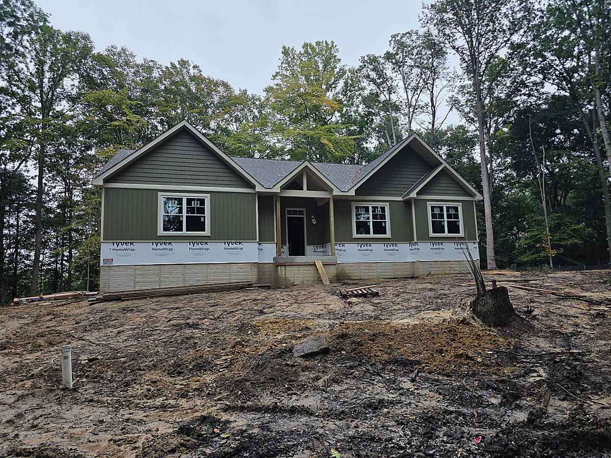 Under construction in Cordova: a rendering of a dark custom home among trees