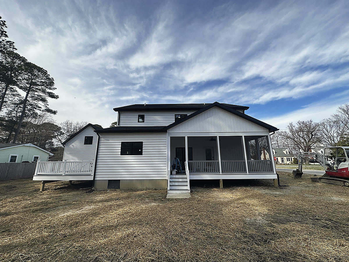A modern farmhouse in St. Michaels: the rear of the farmhouse with its screened porch at sunset