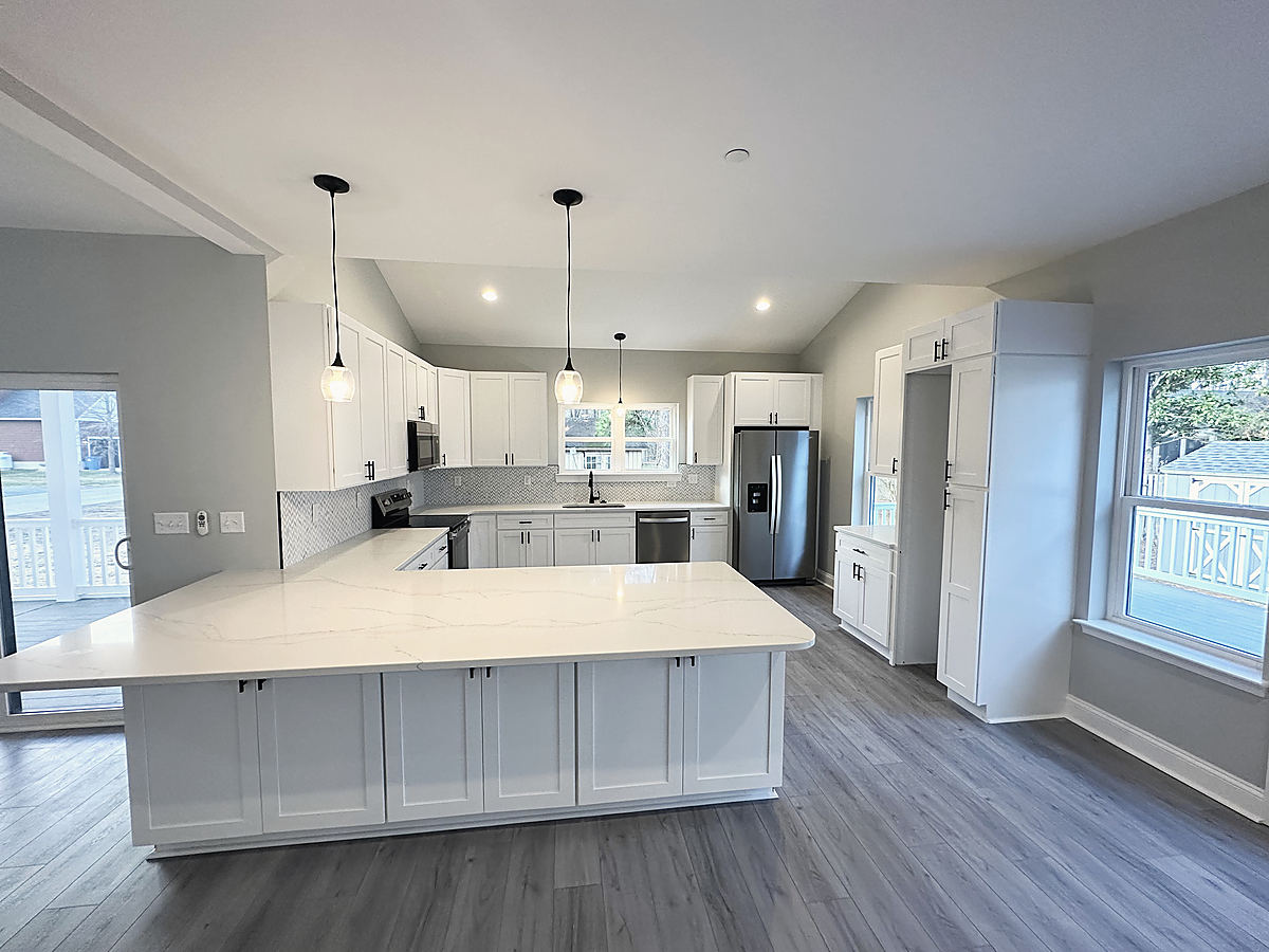 A modern farmhouse in St. Michaels: a white kitchen with an island and black fixtures