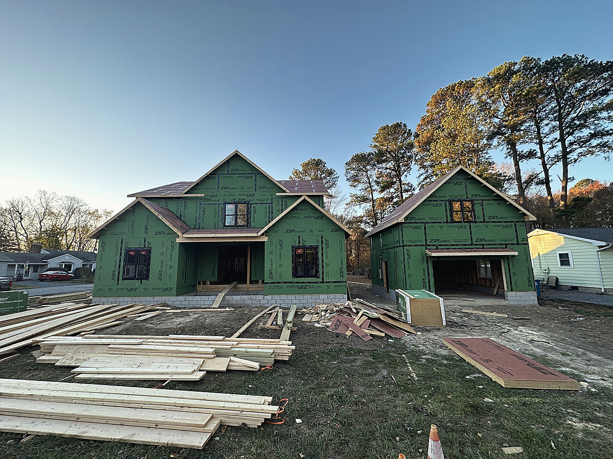 A modern farmhouse in St. Michaels: the new house framed and sheathed in green panels