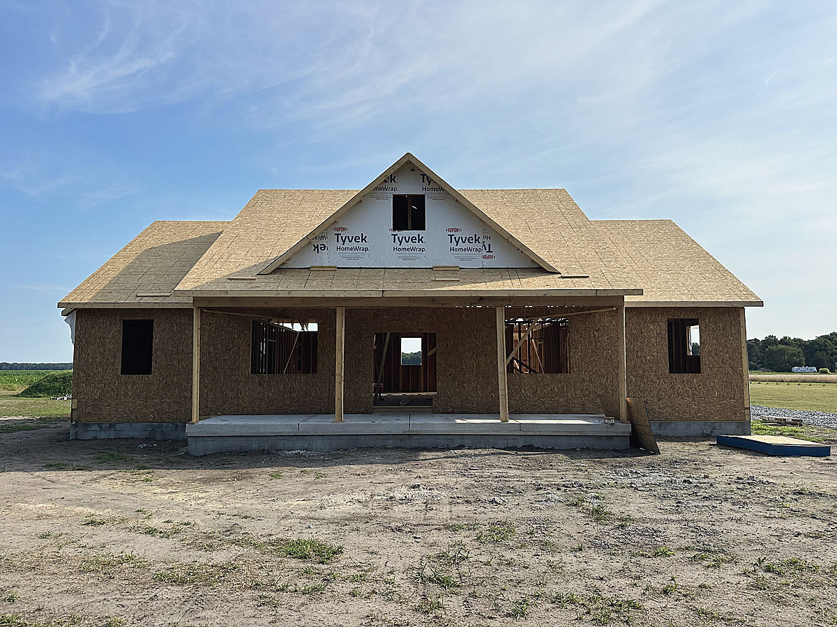 A custom home in Whaleyville: the house framed with its black windows in