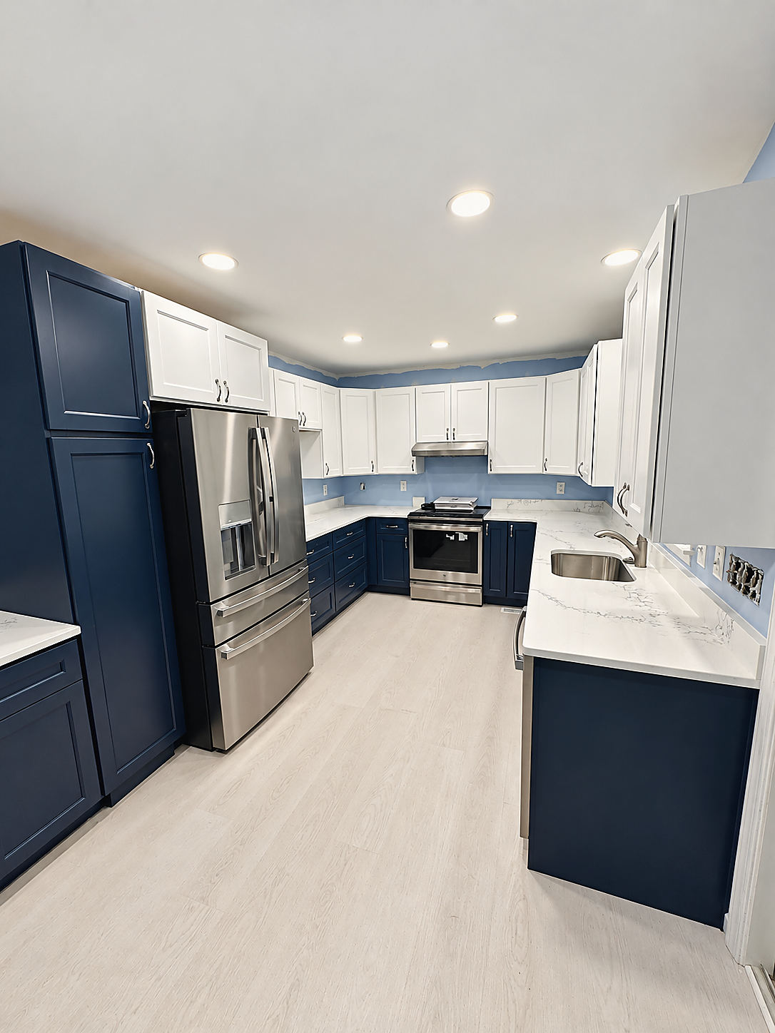 A Del Mar kitchen: navy lower cabinets with white uppers