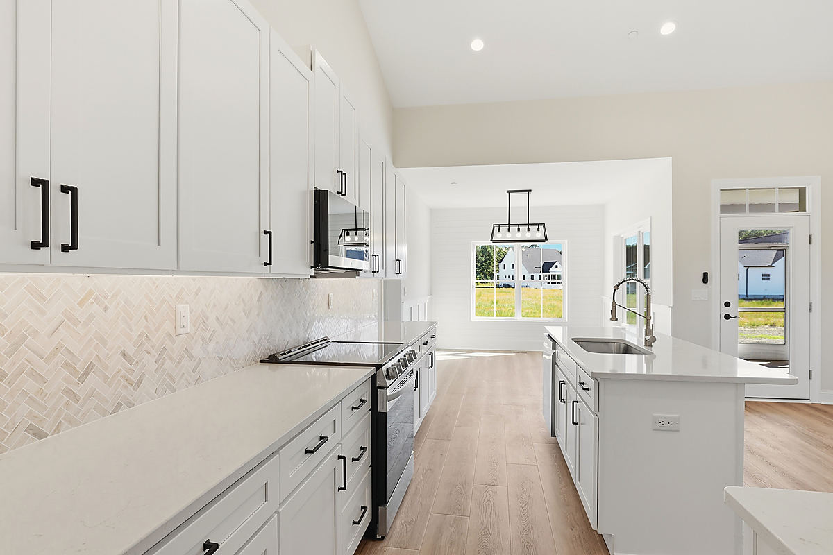 A Del Mar kitchen: a kitchen with a herringbone tile backsplash and an island