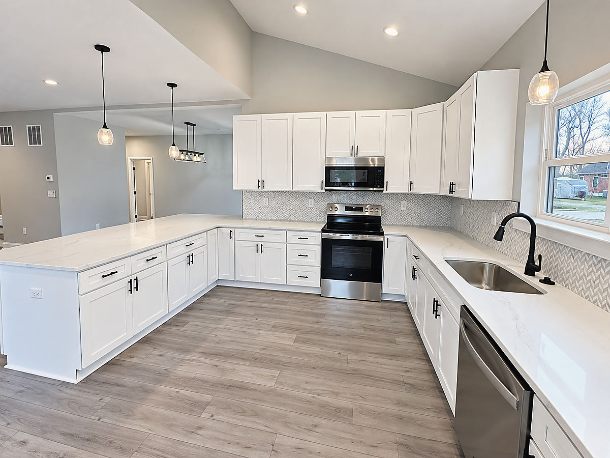A Del Mar kitchen: a white kitchen with stainless appliances and a black faucet