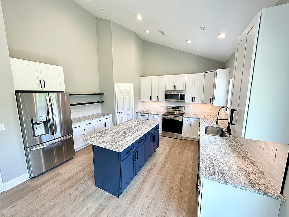 Remodeled kitchen with a navy island and granite counters