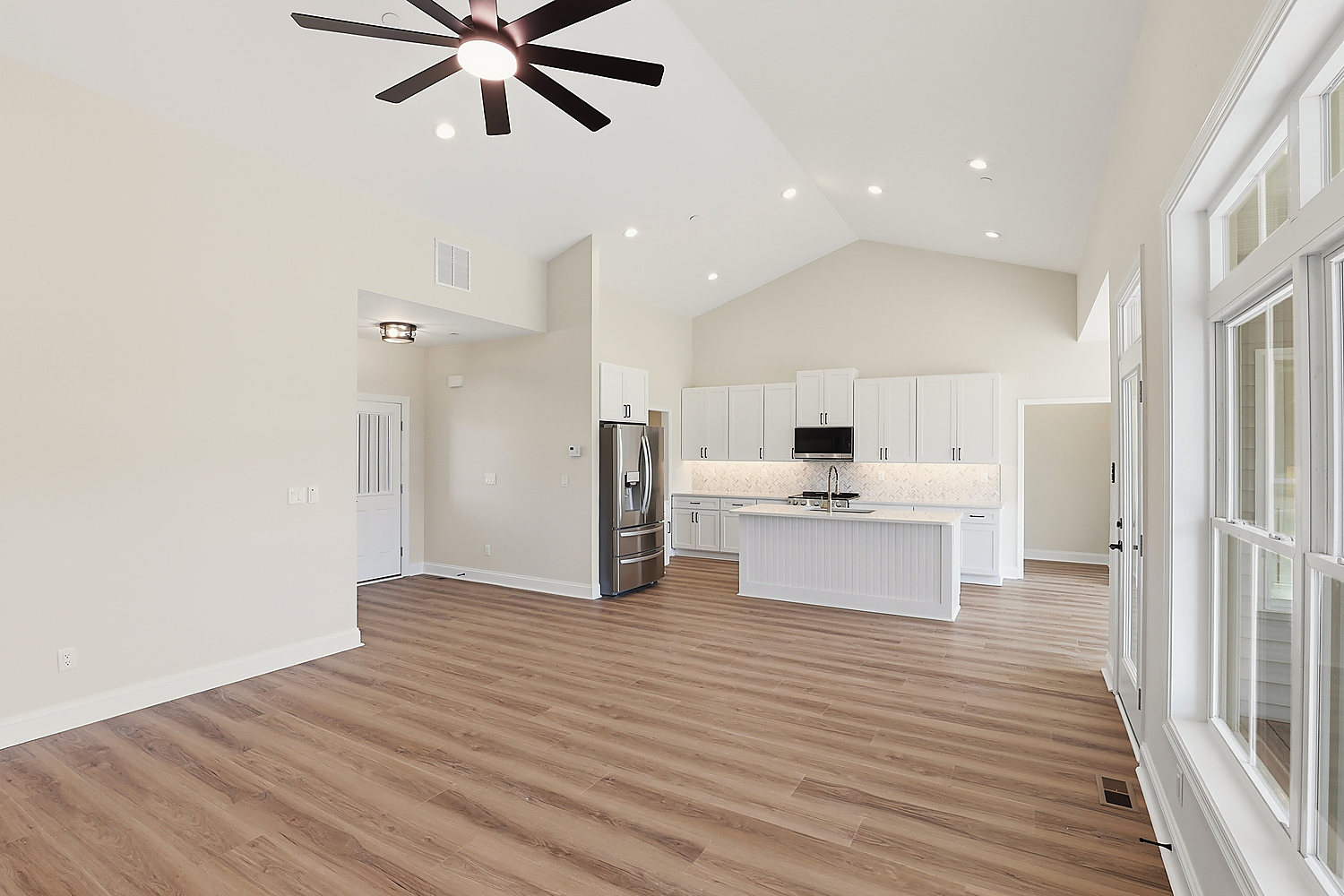 The living room at 5 Seattle Slew Lane: vaulted ceiling, wainscoting and luxury vinyl plank floors