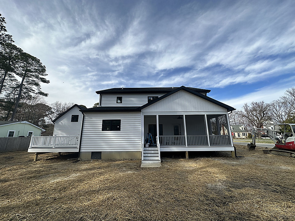 A two-story home with new gutters, deck and screened porch
