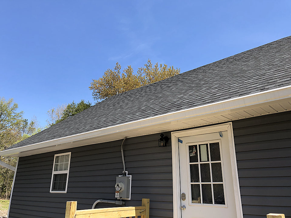 Dark blue vinyl siding with white trim at a rear entry